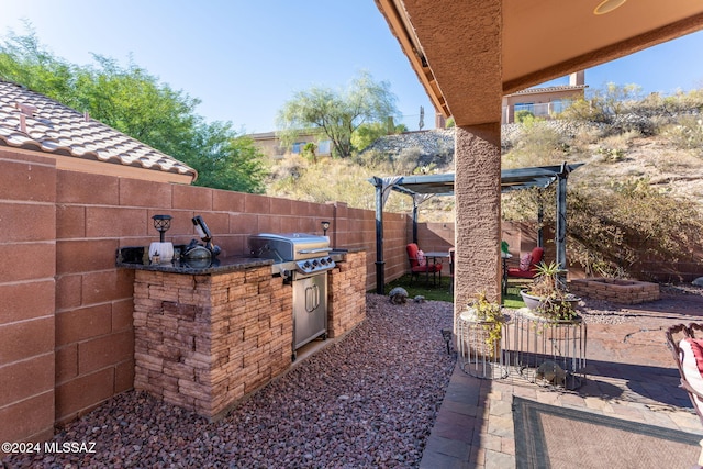 view of patio with area for grilling and a grill