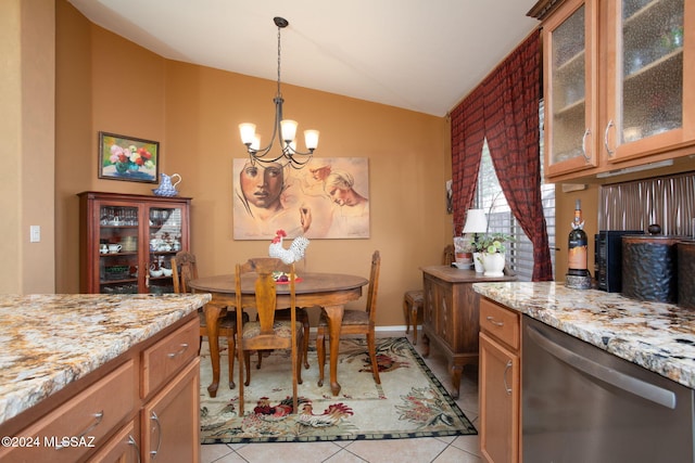 dining space with a chandelier, light tile patterned floors, and vaulted ceiling