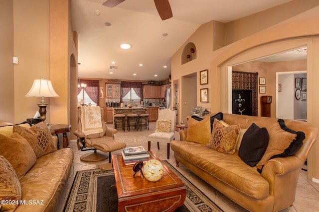 living room featuring lofted ceiling, ceiling fan, and light tile patterned floors