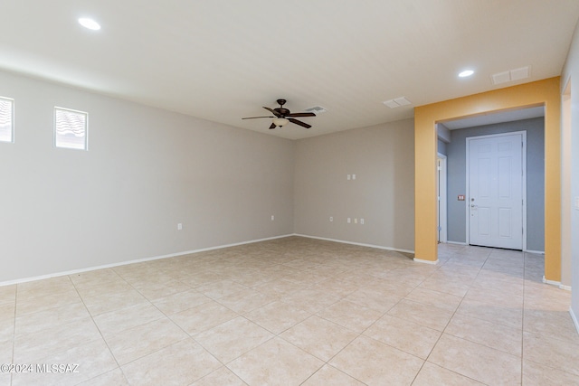 tiled empty room featuring ceiling fan