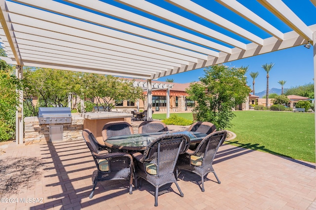 view of patio featuring a pergola, exterior kitchen, and grilling area