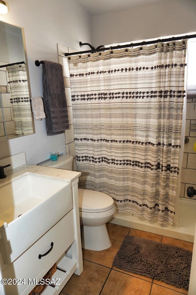 bathroom with vanity, curtained shower, tile patterned floors, and toilet