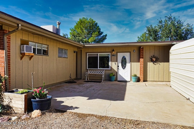 property entrance with a wall mounted AC and a patio