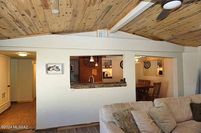 living room featuring vaulted ceiling with beams, wood ceiling, sink, and ceiling fan