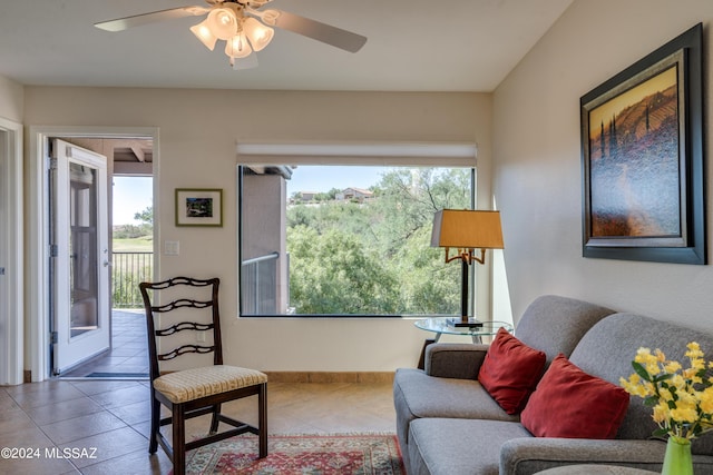 living area with tile patterned flooring and ceiling fan