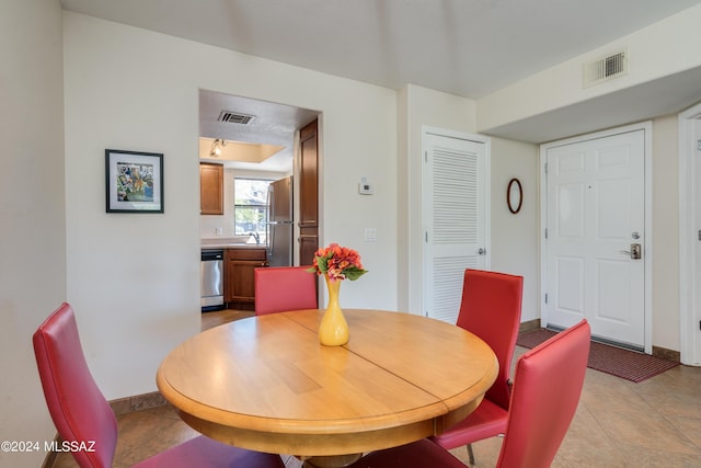 dining room featuring light tile patterned floors, visible vents, and baseboards