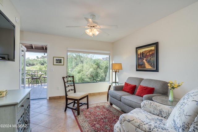 living room with light tile patterned flooring, ceiling fan, and baseboards