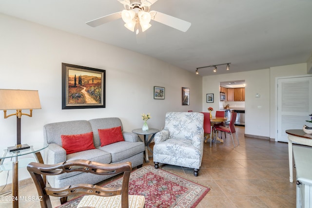 living area featuring ceiling fan, light tile patterned flooring, rail lighting, and baseboards