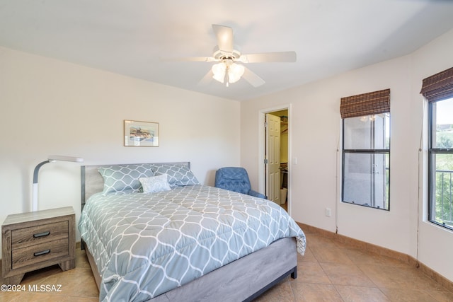 bedroom featuring ceiling fan, multiple windows, tile patterned floors, and baseboards