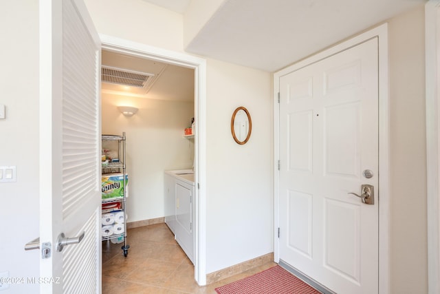 washroom featuring washing machine and dryer and light tile patterned flooring