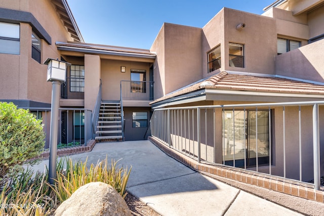 property entrance with a patio area and stucco siding