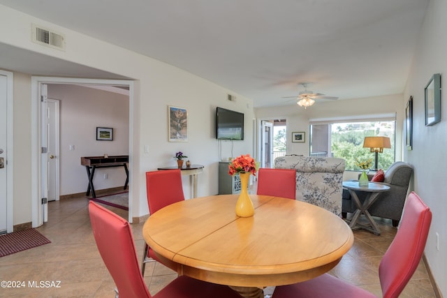 dining space with a ceiling fan, visible vents, baseboards, and light tile patterned floors