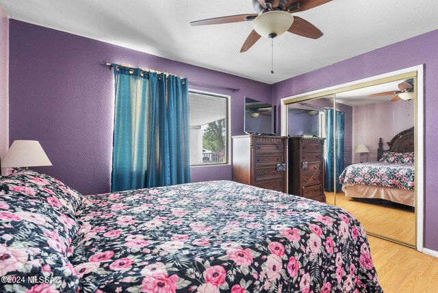 bedroom featuring ceiling fan, a closet, and light hardwood / wood-style flooring