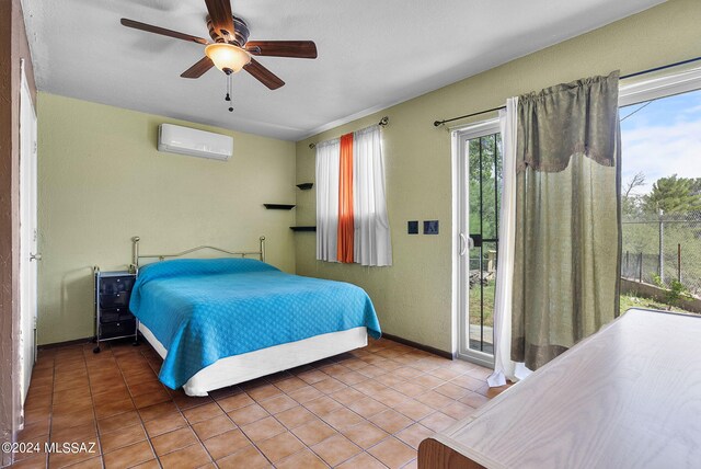 bedroom featuring tile patterned flooring, a wall unit AC, access to exterior, and ceiling fan