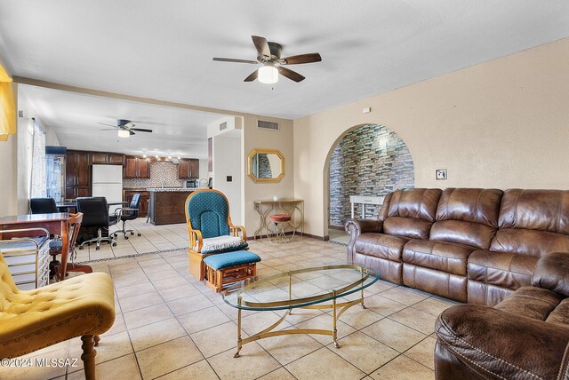 living room with light tile patterned floors, a fireplace, and ceiling fan