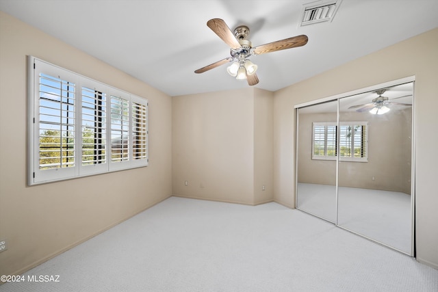 unfurnished bedroom featuring carpet flooring, ceiling fan, and a closet