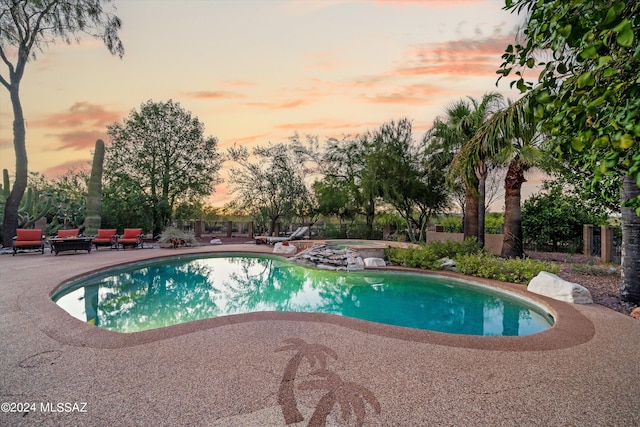 pool at dusk with a patio