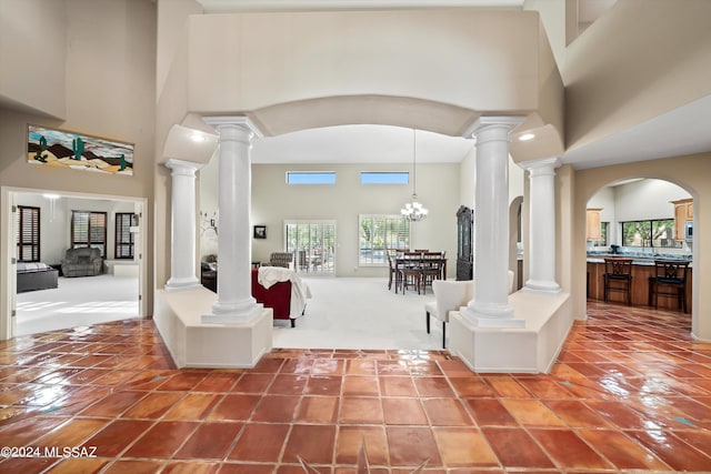 entryway featuring a towering ceiling, tile patterned floors, and a notable chandelier