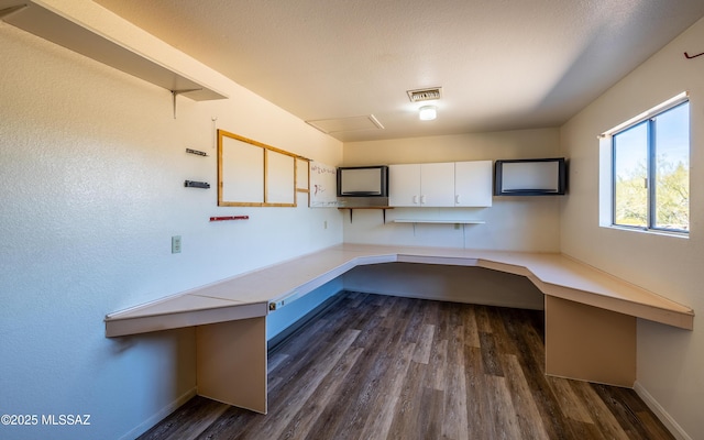 unfurnished office with visible vents, baseboards, dark wood-style flooring, and a textured ceiling