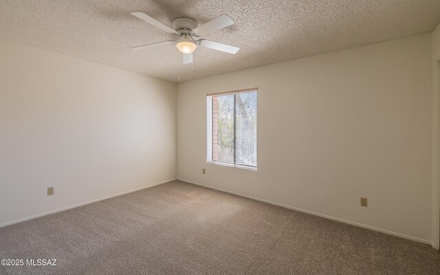 spare room with baseboards, light colored carpet, a textured ceiling, and a ceiling fan