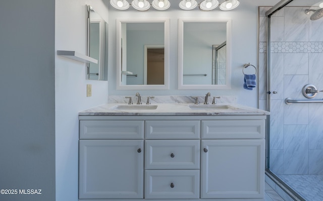 full bathroom with double vanity, tiled shower, and a sink