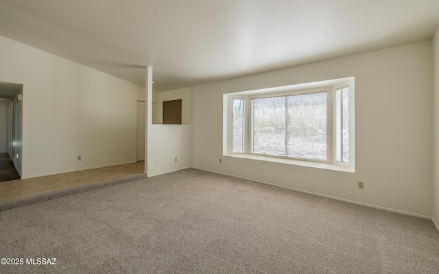 unfurnished living room with baseboards and light colored carpet