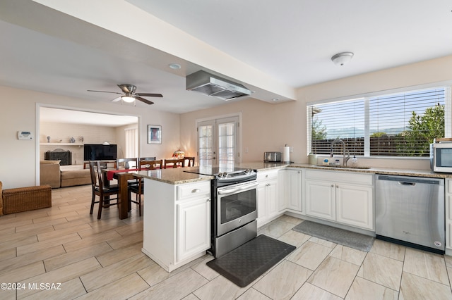 kitchen featuring appliances with stainless steel finishes, a healthy amount of sunlight, white cabinetry, and sink