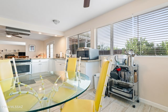 dining area with a wealth of natural light, ceiling fan, and sink