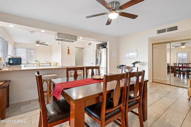 dining space featuring ceiling fan and sink