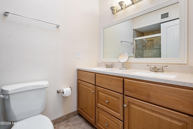 bathroom with tile patterned floors, a shower with shower door, vanity, and toilet