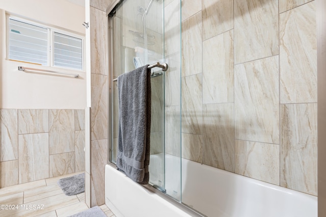 bathroom with combined bath / shower with glass door