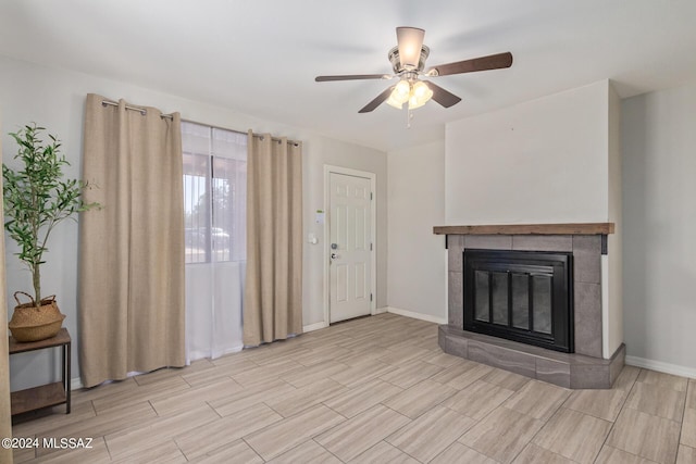 unfurnished living room with ceiling fan and a tile fireplace