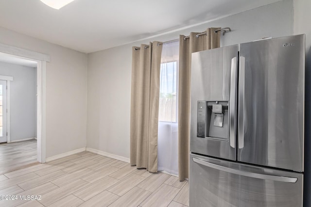 kitchen featuring stainless steel refrigerator with ice dispenser