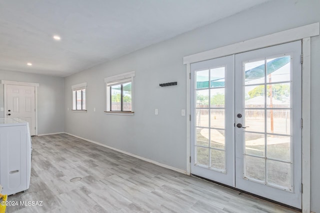 entryway with french doors, light wood-type flooring, and washer / clothes dryer