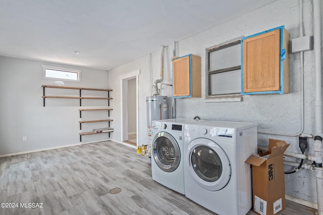 laundry area featuring cabinets, washing machine and dryer, light hardwood / wood-style floors, and gas water heater