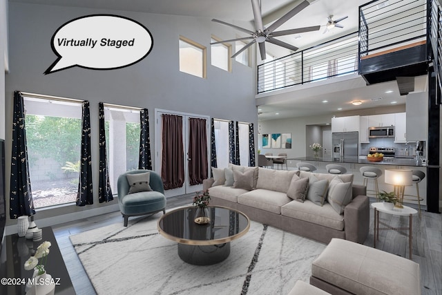 living room with a high ceiling and light wood-type flooring