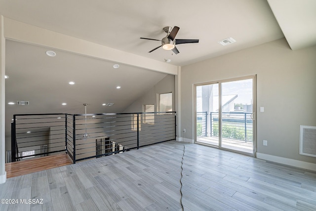 unfurnished room featuring ceiling fan, lofted ceiling, and light hardwood / wood-style floors