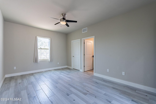 unfurnished bedroom featuring ceiling fan, light wood-type flooring, and ensuite bathroom