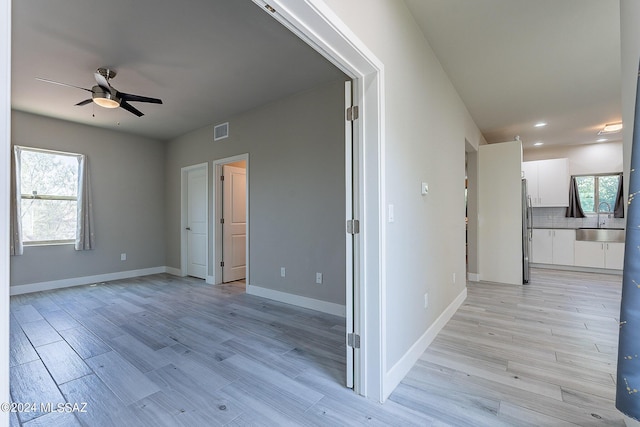 unfurnished living room with ceiling fan, light hardwood / wood-style flooring, and high vaulted ceiling