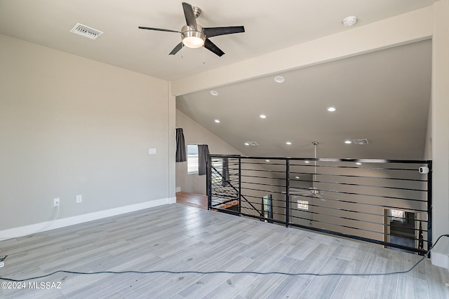 unfurnished room featuring light hardwood / wood-style floors, vaulted ceiling, and ceiling fan