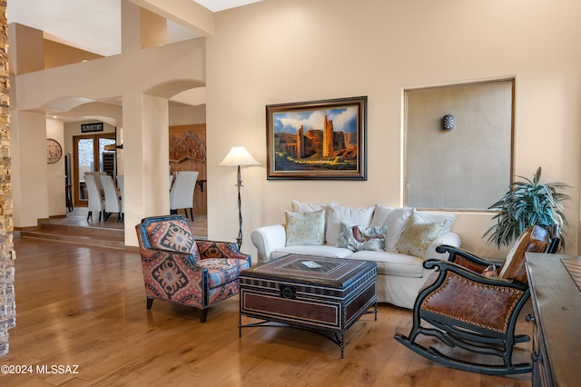 living room featuring hardwood / wood-style flooring and a towering ceiling