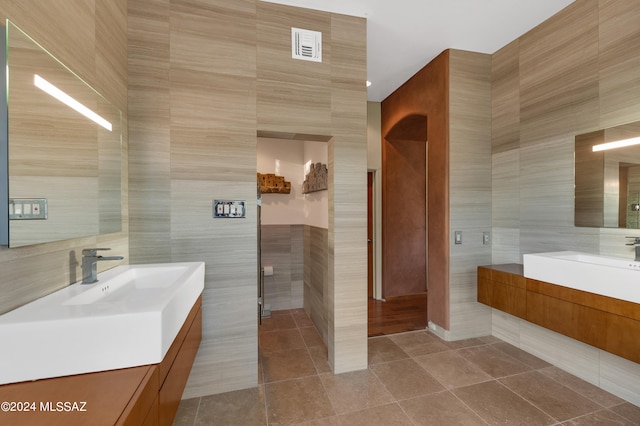 bathroom featuring tile walls, tile patterned floors, and vanity