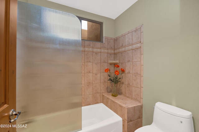 bathroom with toilet and tiled shower / bath combo