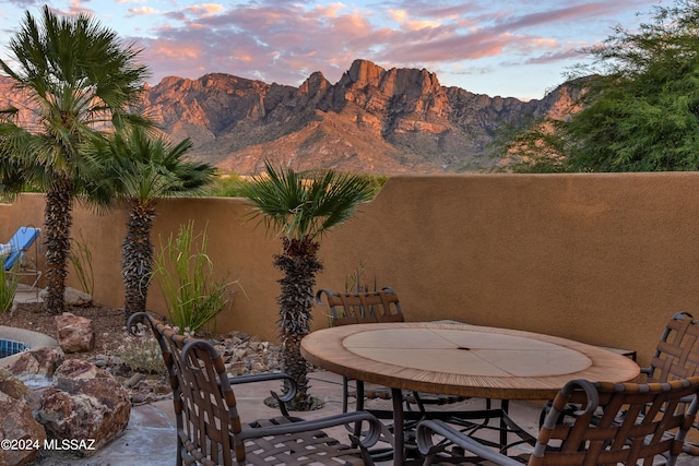 patio terrace at dusk featuring a mountain view