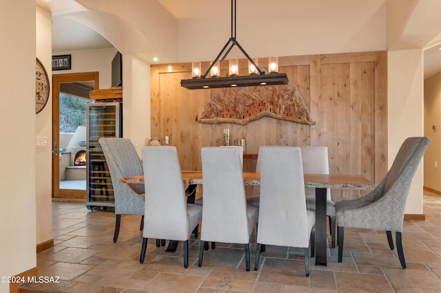 dining area with wood walls and an inviting chandelier