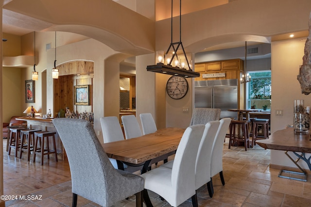 dining space with a towering ceiling and a notable chandelier