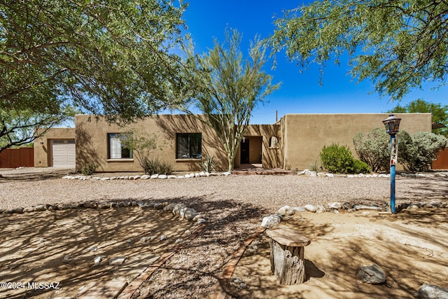 pueblo revival-style home with a garage