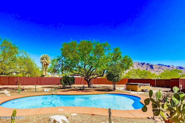 view of swimming pool with a mountain view and a patio area