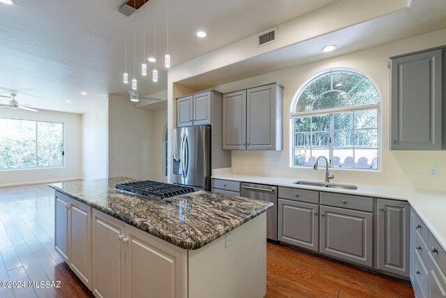 kitchen with ceiling fan, appliances with stainless steel finishes, plenty of natural light, and a kitchen island