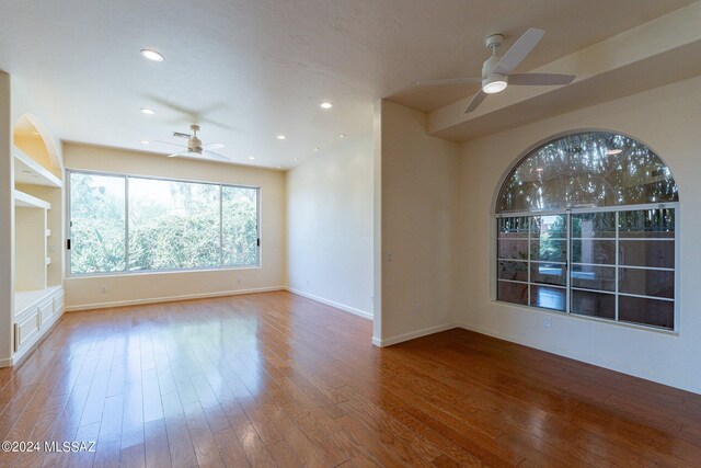 unfurnished room with ceiling fan and hardwood / wood-style flooring